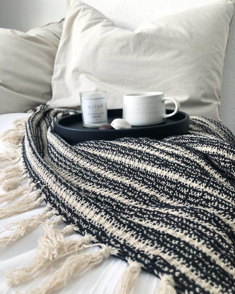 cozy Scandinavian hygge home decor with candles and wool blanket,” “neutral Scandinavian living room with hygge lighting”
